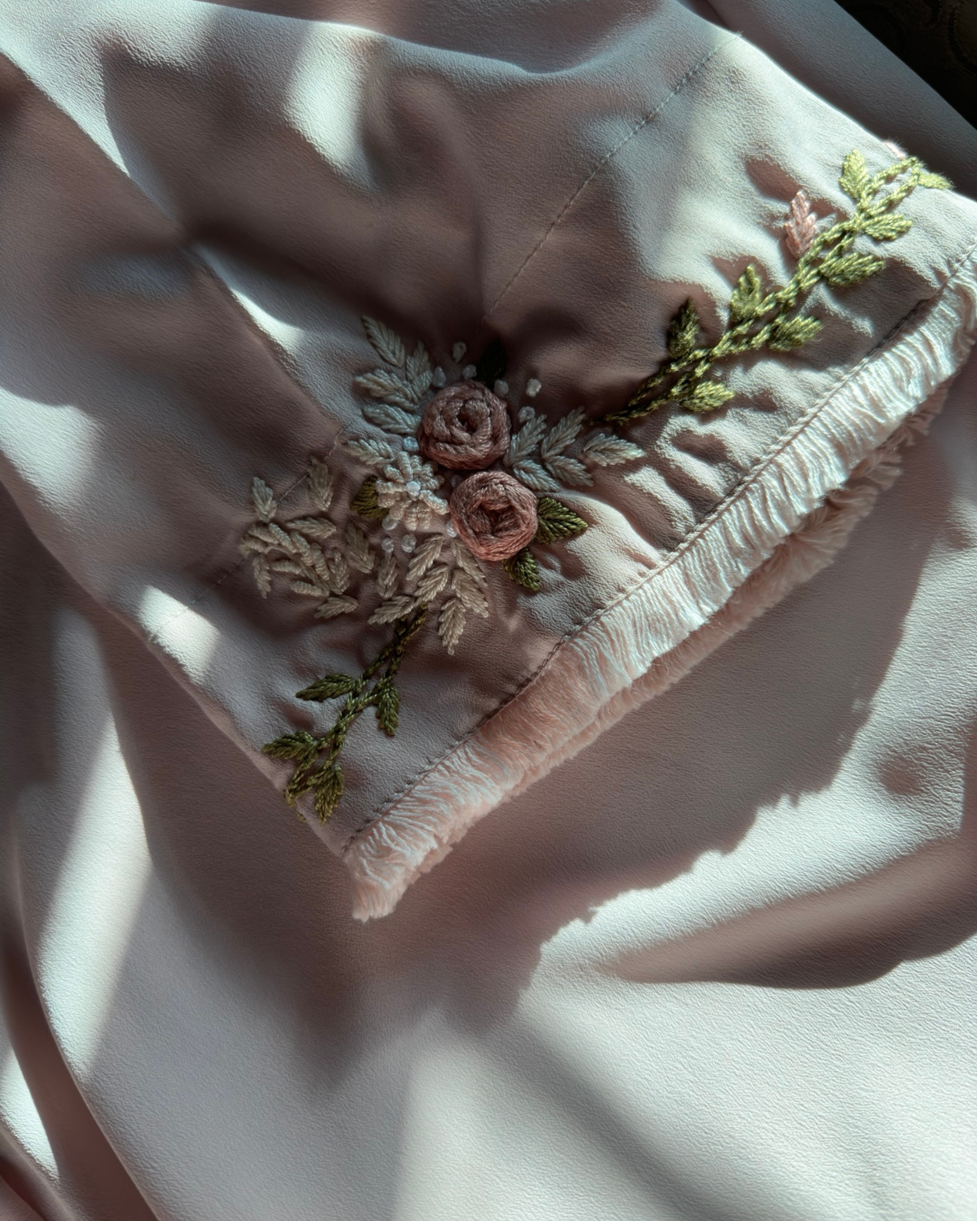 Close-up of hand embroidered sleeves on light pink abaya with delicate lace - artisan modest clothing